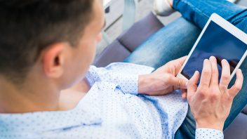 A man using a tablet while seated.