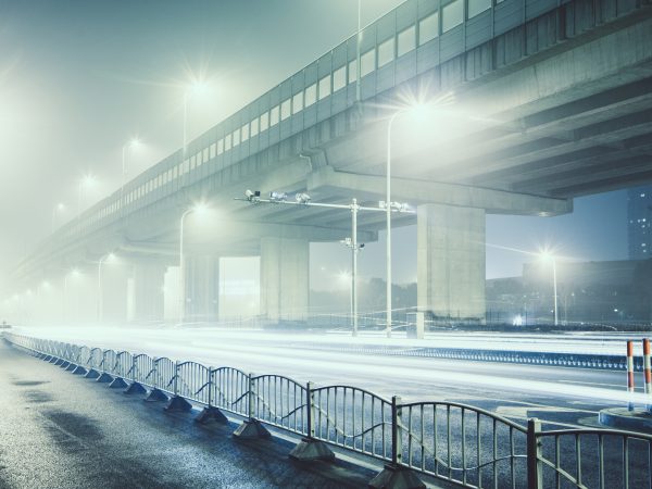 An image of an abandoned city road illuminated by street lights on a cold night in Shanghai, China, illustrating the impact of the Coronavirus.