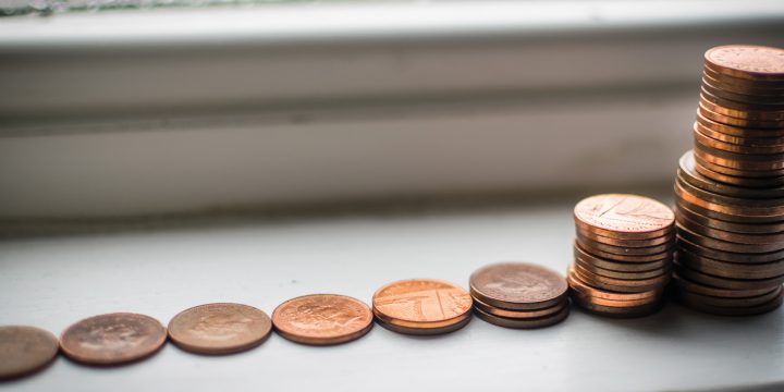 Photograph of a row of coins with them being stacked at the end.