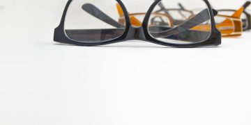 A photo zoomed in on a pair of eyeglasses in a row of other eyeglasses fading into the background.
