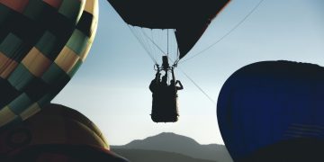Silhouette of hot air balloon rising - concept of adventure and success. 