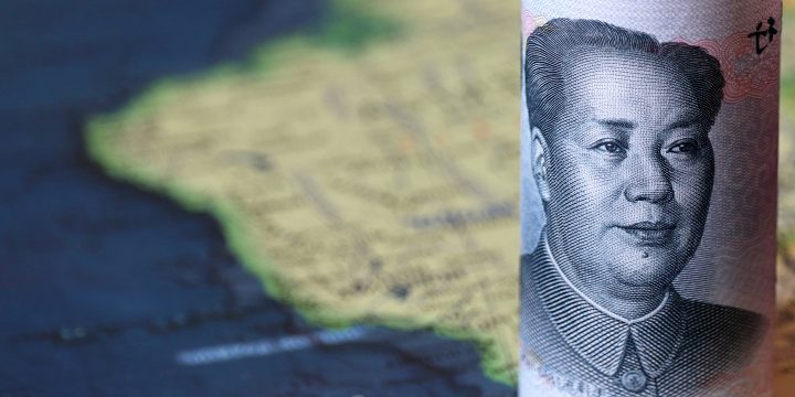 A rolled-up Chinese yuan on a map of South America 
