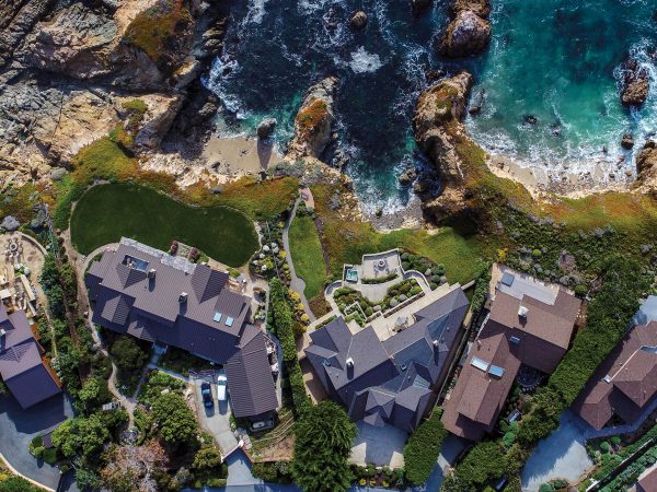 An aerial image of houses along a rocky coastline